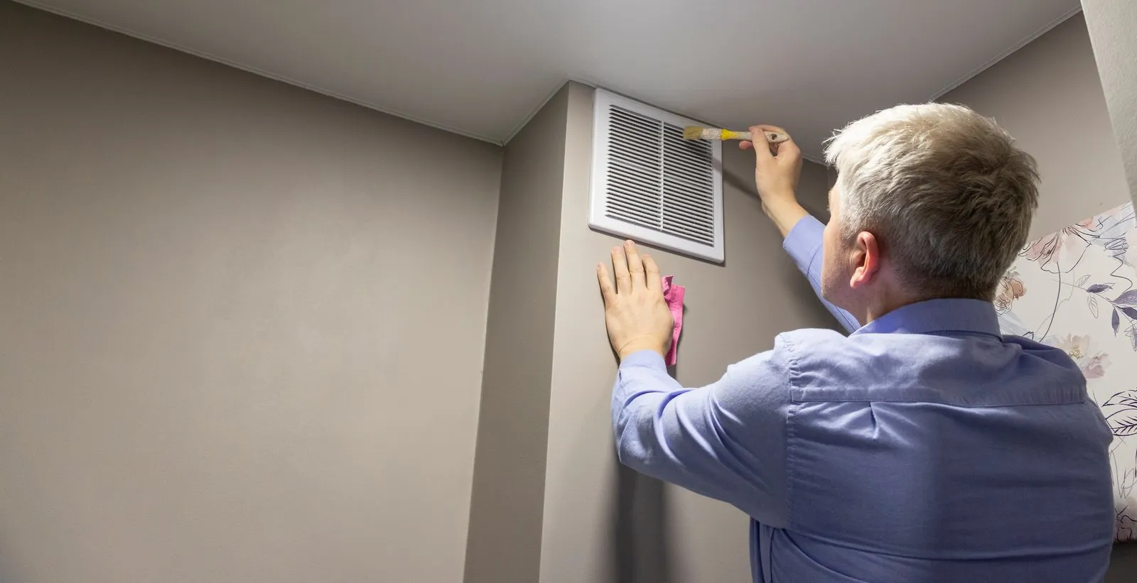 Illustrative stock photo — a technician cleaning an HVAC return air vent and duct; not an actual Lake Havasu AC Guide job site.