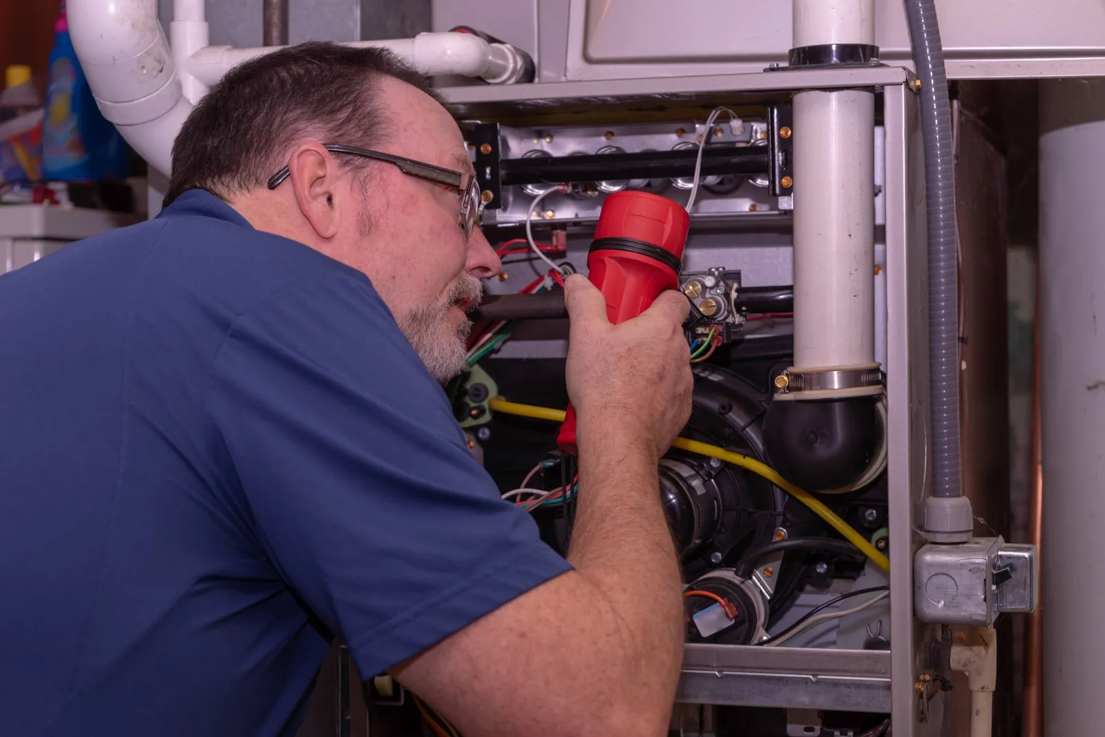 Illustrative stock photo — a technician servicing a residential gas furnace; not an actual Lake Havasu AC Guide job site.